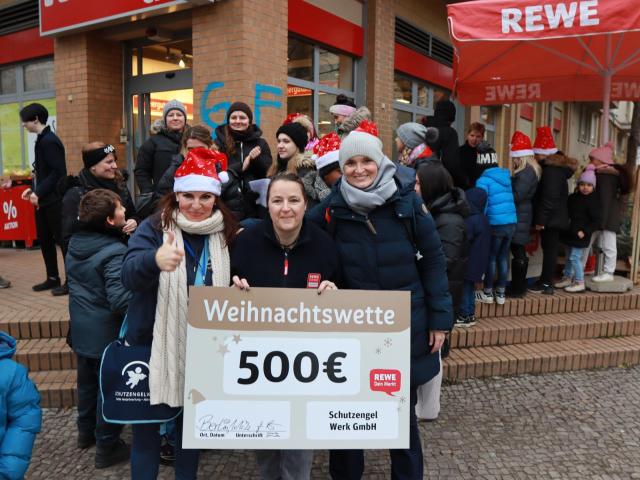 Wette gewonnen! Drei Frauen vor REWE mit einem Scheck