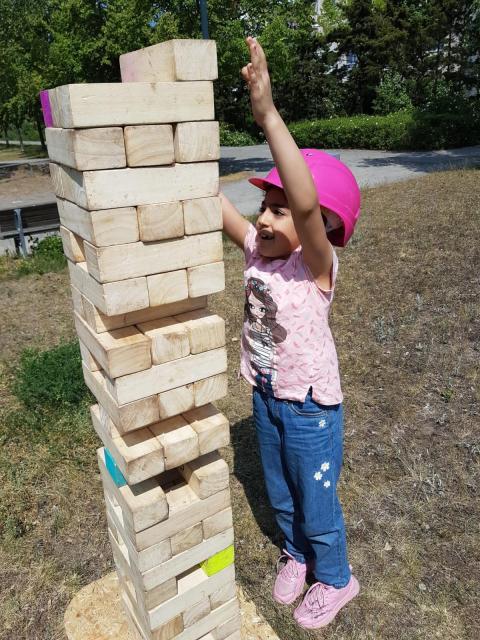 ein Mädchen baut einen Jenga-Turm