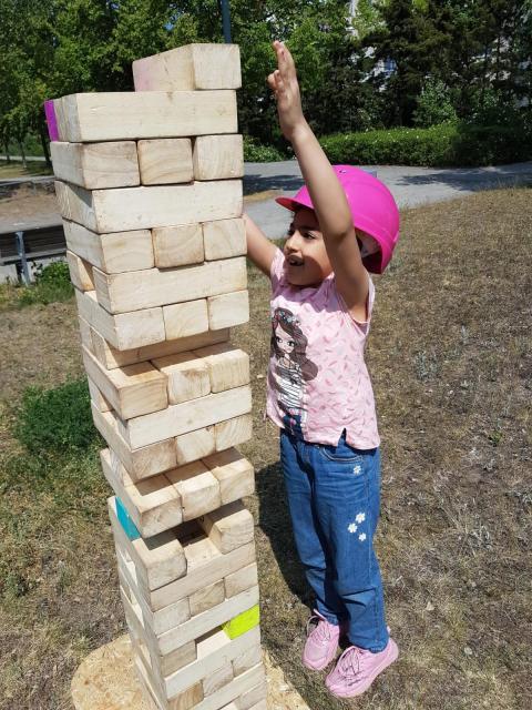 Der Jenga-Turm war größer als das Mädchen ein Mädchen baut einen Jenga-Turm