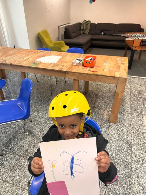 ein kleiner junge mit einem selbst gemalten Osterbild in der Hand