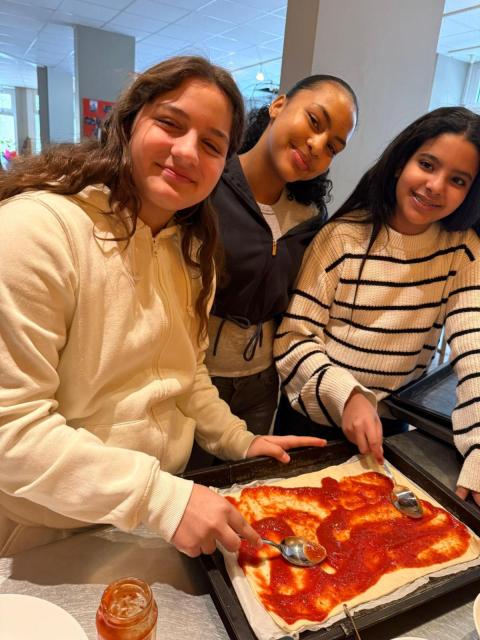 Kinder helfen beim Zubereiten einer Pizza im Schutzengel-Haus