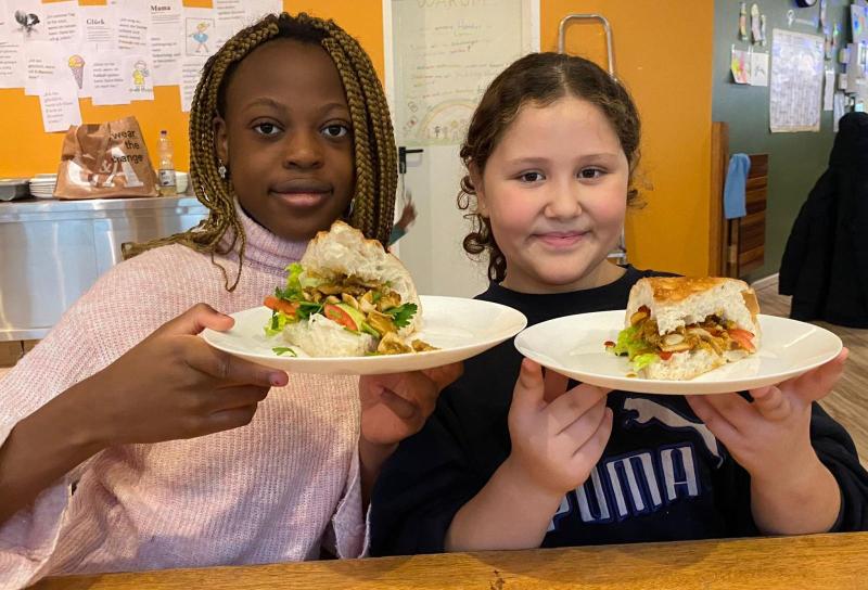 Das Mittagsangebot im Schutzengel-Haus ist wichtig für viele Kinder zwei Mädchen halten selbstgemachte Sandwiches in der Hand
