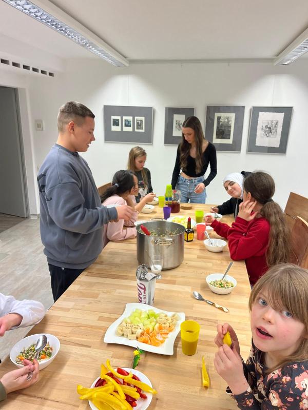 Kinder sitzen am Tisch und genießen das kostenlose gesunde Mittagessen