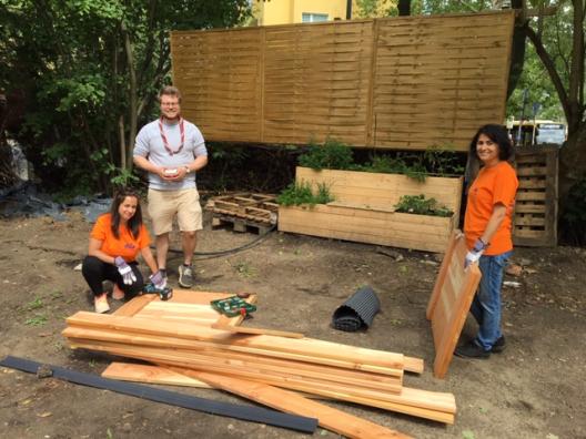 Menschen vor Holzstapel.