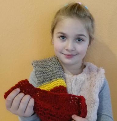 Mädchen mit selbstgestrickten Schal in der Hand