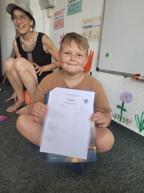 ein Junge mit seinem Zeugnis