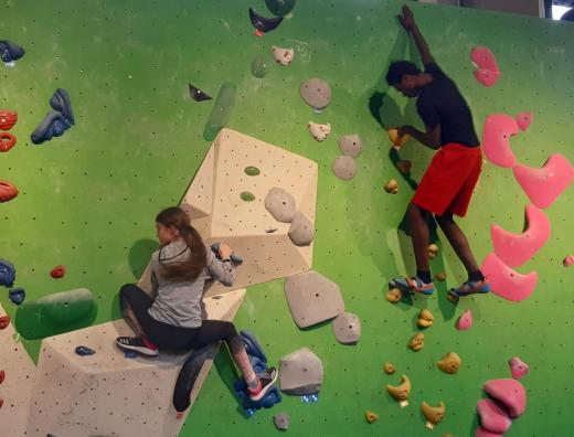 zwei Kinder an einer Boulderkletterwand