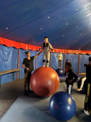 ein Junge auf einem Ball im Zirkus CABUWAZI
