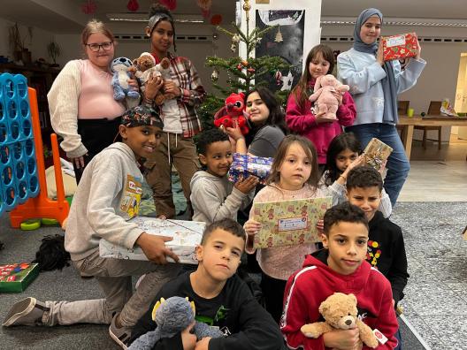Kinder in einer sozialen Einrichtung freuen sich über ihre Weihnachtsgeschenke
