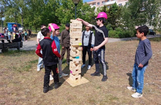 Kinder spielen mit einem Riesen-Jenga