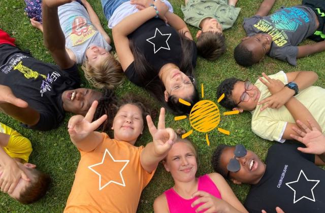 Kinder liegen auf der Sommerwiese
