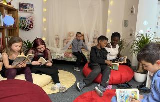 Kinder lesen in einer gemütlichen Leseecke Bücher