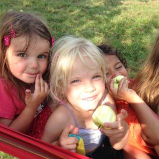 Kinder mit Apfel in Hängematte