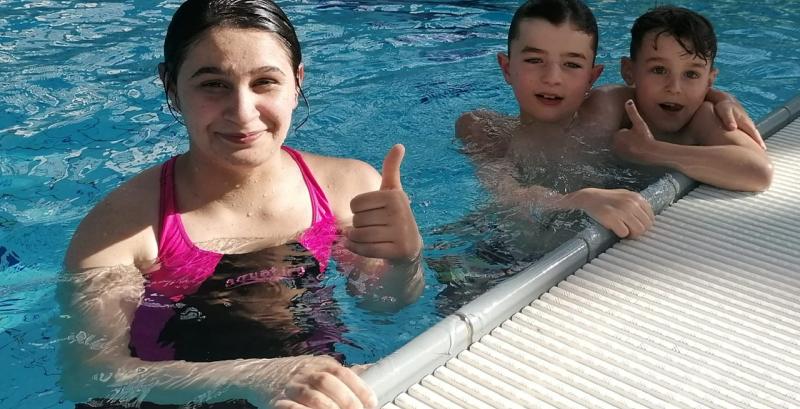 drei Kinder im Wasser lernen schwimmen