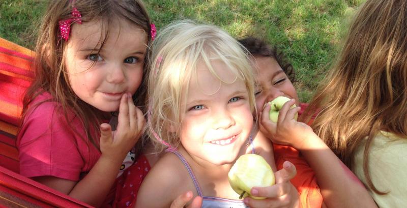 Kinder mit Apfel in Hängematte